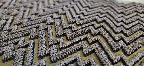 Esempio ricamo molto tridimensionale su vera pelle. Geometria ricamata in 3d con filato lucido